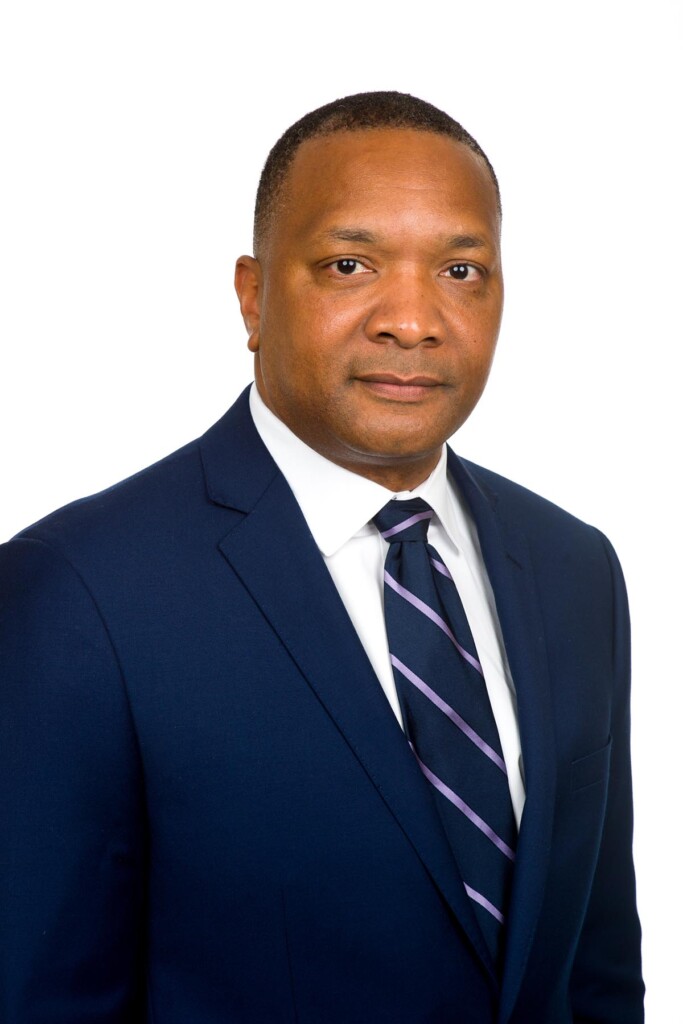 A photograph of Dr. Marcus Jones in a blue blazer and tie.